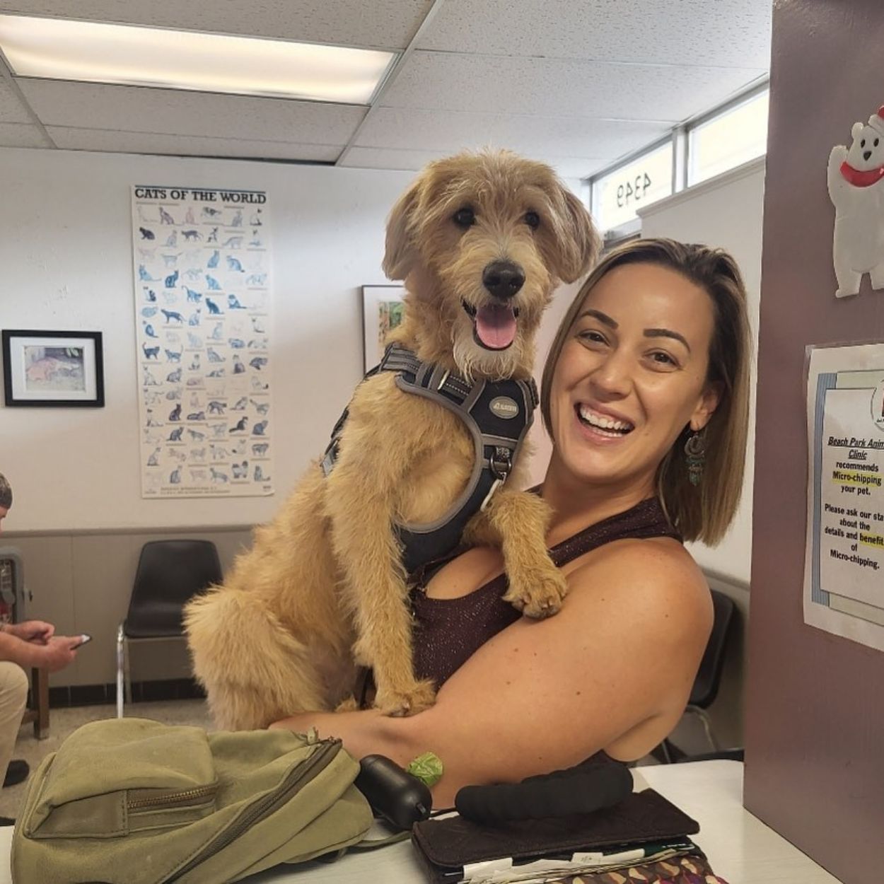 A lady joyfully holding her dog